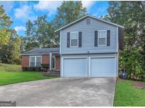 Two-story home with a brick and siding facade, a driveway, and a well-manicured lawn at 3823 Rock Hollow Ct, Conley, GA 30288