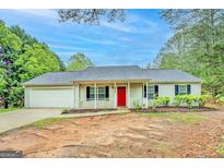 Charming single-story home featuring a well-maintained lawn, inviting front porch, and bright red front door at 4547 Atha Cir, Loganville, GA 30052