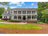 Inviting two-story home with a double-decker porch and well-manicured lawn at 607 Lees Mill Rd, Fayetteville, GA 30214