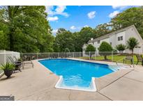 Inviting in-ground pool with a diving board and surrounding patio space, perfect for outdoor entertaining at 607 Lees Mill Rd, Fayetteville, GA 30214