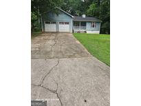Charming single-story home with a spacious front yard and a two-car garage at 115 Lakeview Dr, Stockbridge, GA 30281