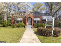 Charming brick home with a well-manicured lawn and beautiful flowering tree in the front yard at 109 Stockbridge Rd, Jonesboro, GA 30236