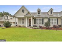 Charming home with a well-manicured lawn, beautiful landscaping, and a welcoming front entrance at 1025 Pinehurst Dr, Peachtree City, GA 30269