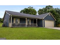 Charming single-story home with a covered front porch, attached garage, and well-maintained lawn at 6403 Heritage Run, Morrow, GA 30260