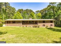 Charming brick home with manicured front yard and mature trees, perfect for suburban living at 160 Pine Trail Rd, Fayetteville, GA 30214