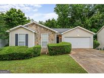 Charming single-story home featuring stone accents, manicured landscaping, and an attached two-car garage at 520 Lakecourt Dr, Mcdonough, GA 30253
