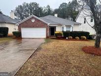 Charming single-story home featuring a brick facade and a well-maintained front lawn at 165 Lakeside Pt, Covington, GA 30016