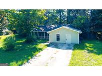 Cozy one-story home featuring a quaint front yard, covered porch, and inviting curb appeal at 8846 Wesley Pl, Jonesboro, GA 30238