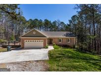 Charming brick home with an attached two-car garage and a spacious front yard in a wooded, tranquil neighborhood at 6340 Koweta Rd, Fairburn, GA 30213
