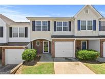 Charming townhome featuring a brick facade, garage, and manicured landscaping at 695 Georgetown Ct, Jonesboro, GA 30236