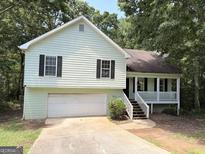 Charming two-story home featuring a front porch and two-car garage, surrounded by mature trees at 270 Mountain Way, Covington, GA 30016
