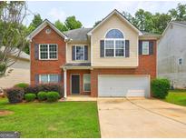 Charming two-story home with well-maintained lawn, brick facade, and attached two-car garage at 2093 Parador Bnd, Mcdonough, GA 30253