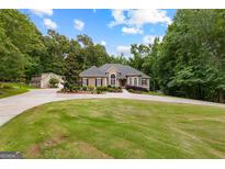 Stunning stucco home with mature landscaping, circular driveway, and attached garage at 285 Spear Rd, Peachtree City, GA 30269