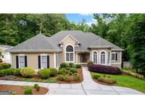 Inviting traditional home boasting a manicured lawn, beautiful landscaping, and a welcoming facade with arched windows at 285 Spear Rd, Peachtree City, GA 30269