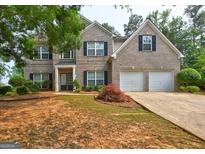 Traditional brick home with an attached two-car garage and well-maintained landscaping at 1132 Hargrove Ct, Locust Grove, GA 30248