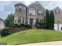 Charming two-story brick home with manicured landscaping and a welcoming front entrance at 3717 Shady Maple Dr, Stonecrest, GA 30038