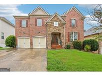 Beautiful two-story brick home featuring a manicured lawn and two-car garage at 1476 Rolling View Way, Dacula, GA 30019