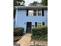 Charming blue townhome featuring black shutters, a black front door, and well-maintained landscaping at 375 Leisure Sw Ct, Marietta, GA 30064