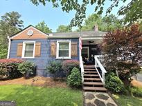 Charming home featuring a landscaped front yard and a welcoming front porch at 3226 Hope St, Hapeville, GA 30354