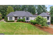 Stately home boasts a manicured lawn, mature trees, and sophisticated architectural details at 4030 River Ridge Chase Se, Marietta, GA 30067