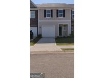 Charming townhome features a one-car garage, inviting entrance, and well-maintained front yard at 11992 Fuller St, Hampton, GA 30228