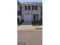 Charming townhouse with a one-car garage, black shutters, and a well-manicured lawn at 11992 Fuller St, Hampton, GA 30228