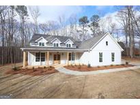 Charming two-story home with a welcoming front porch and beautifully landscaped front yard at 84 Puckett Station Drive Dr, Moreland, GA 30259