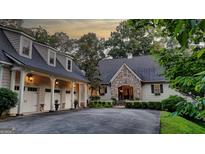 Charming home features a stone facade, three-car garage, and a circular driveway surrounded by lush landscaping at 223 Old Rome Rd, Kingston, GA 30145