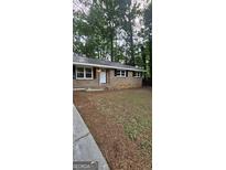 Charming single-story brick home with a metal roof and traditional black shutters at 4059 Canby Ln, Decatur, GA 30035