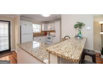 Bright kitchen features white appliances, granite counters, and hardwood flooring at 482 N Jeff Davis Dr, Fayetteville, GA 30214