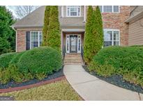 Charming home entrance featuring manicured landscaping and a welcoming front door at 135 Edgewater Trl, Fayetteville, GA 30215