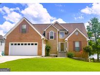 Charming two-story home featuring a brick and siding exterior, manicured lawn and two-car garage at 105 Providence Ct, Carrollton, GA 30116