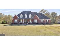 Classic brick home with a covered porch and well-kept front yard at 395 W Mcintosh Rd, Brooks, GA 30205