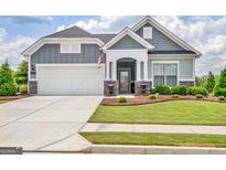 Charming gray two-story home with landscaped yard and covered entryway and well manicured lawn at 411 Southbridge Pass, Peachtree City, GA 30269