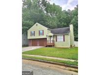 Charming two-story home features a two-car garage, well-maintained lawn and mature trees at 35 Hampton Oaks Dr, Hampton, GA 30228