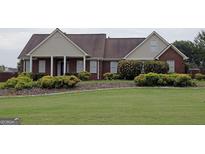 Charming brick home featuring a well-manicured lawn and a welcoming front porch with classic white columns at 1204 Bent Creek Dr, Mcdonough, GA 30252