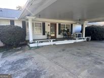 Charming brick home featuring an attached carport with a covered front porch and ample seating at 4160 Ewing Rd, Austell, GA 30106