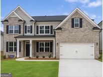 Charming two-story home with a brick facade, black shutters, well-manicured lawn, and attached two car garage at 3468 Jasmine Way Sw, South Fulton, GA 30331