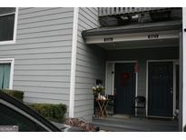 Charming townhome entrance featuring a cozy porch with seating and a decorative front door at 1602 Riverbend Club Drive, Atlanta, GA 30339