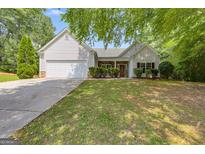 Charming single Gathering home with a well-manicured lawn and traditional white siding at 305 Overland Trl, Temple, GA 30179