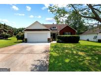 Charming single-Gathering home with a well-manicured lawn, brick accents, and a two-car garage at 8180 Chapman Ter, Mcdonough, GA 30252