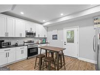 Well-lit kitchen with white cabinets, stainless steel appliances, and a central island with seating at 1174 Princess Sw Ave, Atlanta, GA 30310