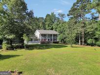 Charming two-story home featuring a spacious lawn and a classic colonial design with mature trees at 437 Mays Rd, Stockbridge, GA 30281