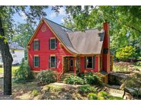 Charming red two-story home with inviting stone-accented front porch and mature landscaping at 3498 Overland Trl, Ellenwood, GA 30294