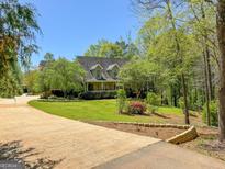 Charming single-Gathering home featuring a well-manicured lawn, mature trees, and a long private driveway at 1561 Aiken Chafin Ln, Mcdonough, GA 30252