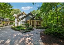 Charming home showcasing meticulous landscaping, stone walkway, and a welcoming front porch with classic American flag at 508 Hastings Dr, Peachtree City, GA 30269