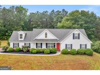 Charming one-story home with a landscaped front yard and a red front door at 506 Brewer Dr, Locust Grove, GA 30248