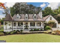 Charming home featuring a welcoming front porch, black shutters, and manicured landscaping at 870 Rutherford Dr, Dacula, GA 30019