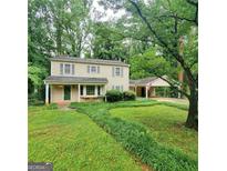 Charming two-story home with a covered front porch, carport, and lush green landscaping at 3325 Pebble Hill Dr, Marietta, GA 30062