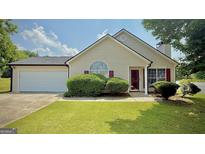 Charming single Gathering home with a well-maintained lawn, attached garage, and manicured landscaping at 6638 Creek Turn Dr, Rex, GA 30273